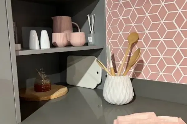 Grey minimal kitchen worktop with pink geometric tiles. 