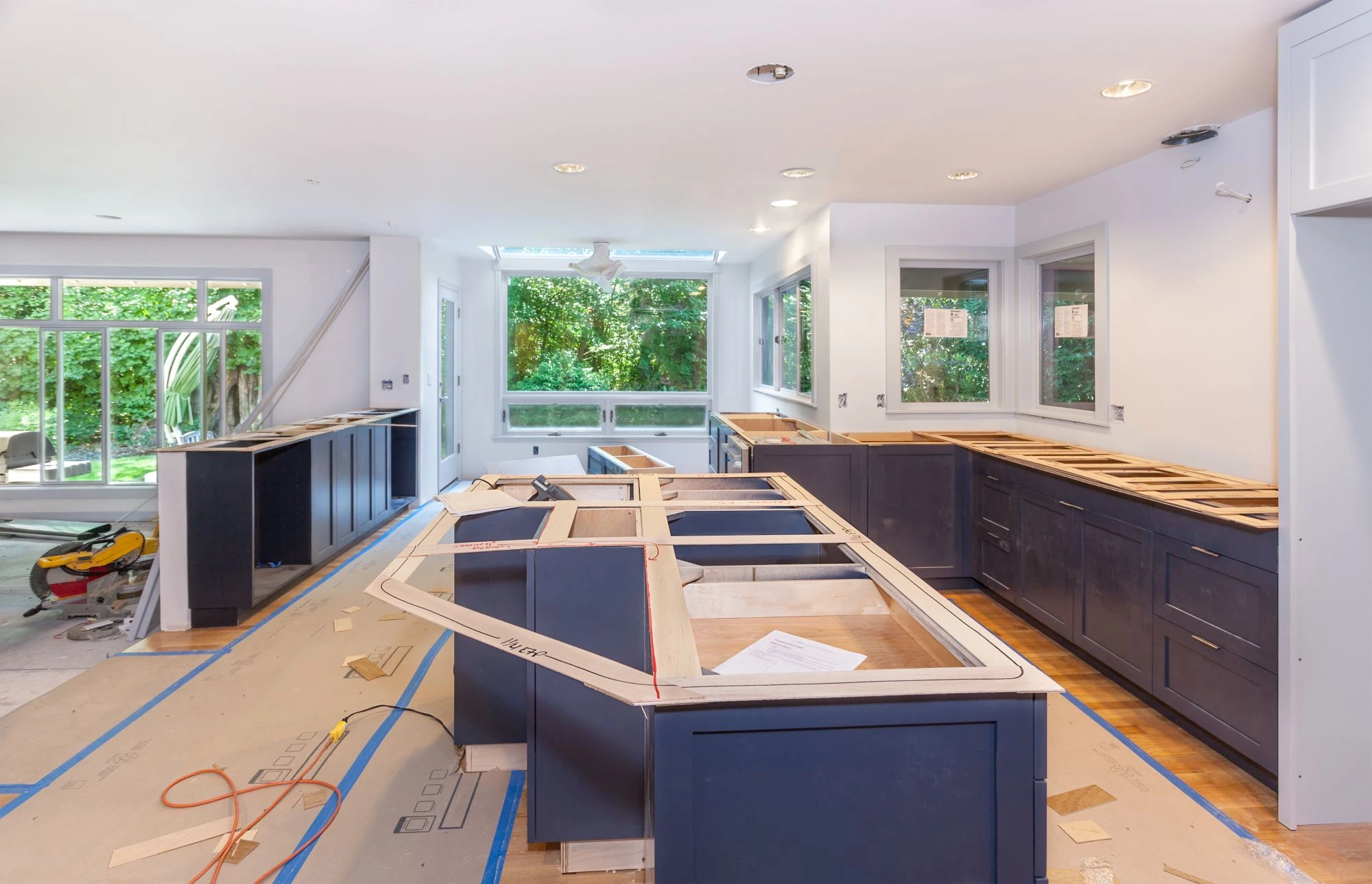 A large modern kitchen in the middle of a renovation, with countertops yet to be installed.