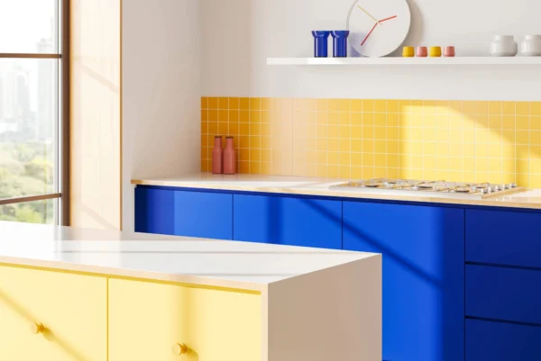 A brightly lit, modern kitchen features bold yellow subway tiles on the backsplash and royal blue handleless base cabinets.