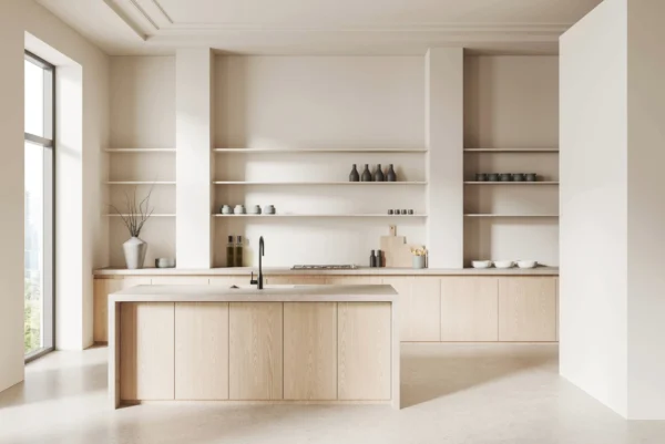 A bright, minimalist kitchen is centred around a light wood island with a sink and black faucet.