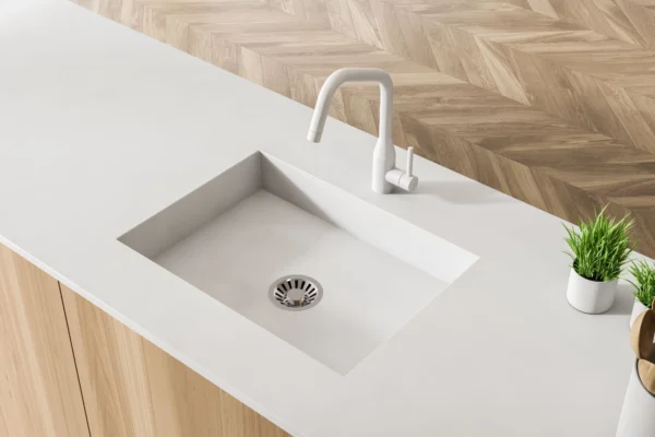 A clean, integrated white sink with a white tap.