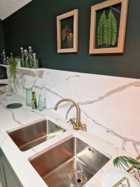 A double stainless steel undermount sink with a brass tap.