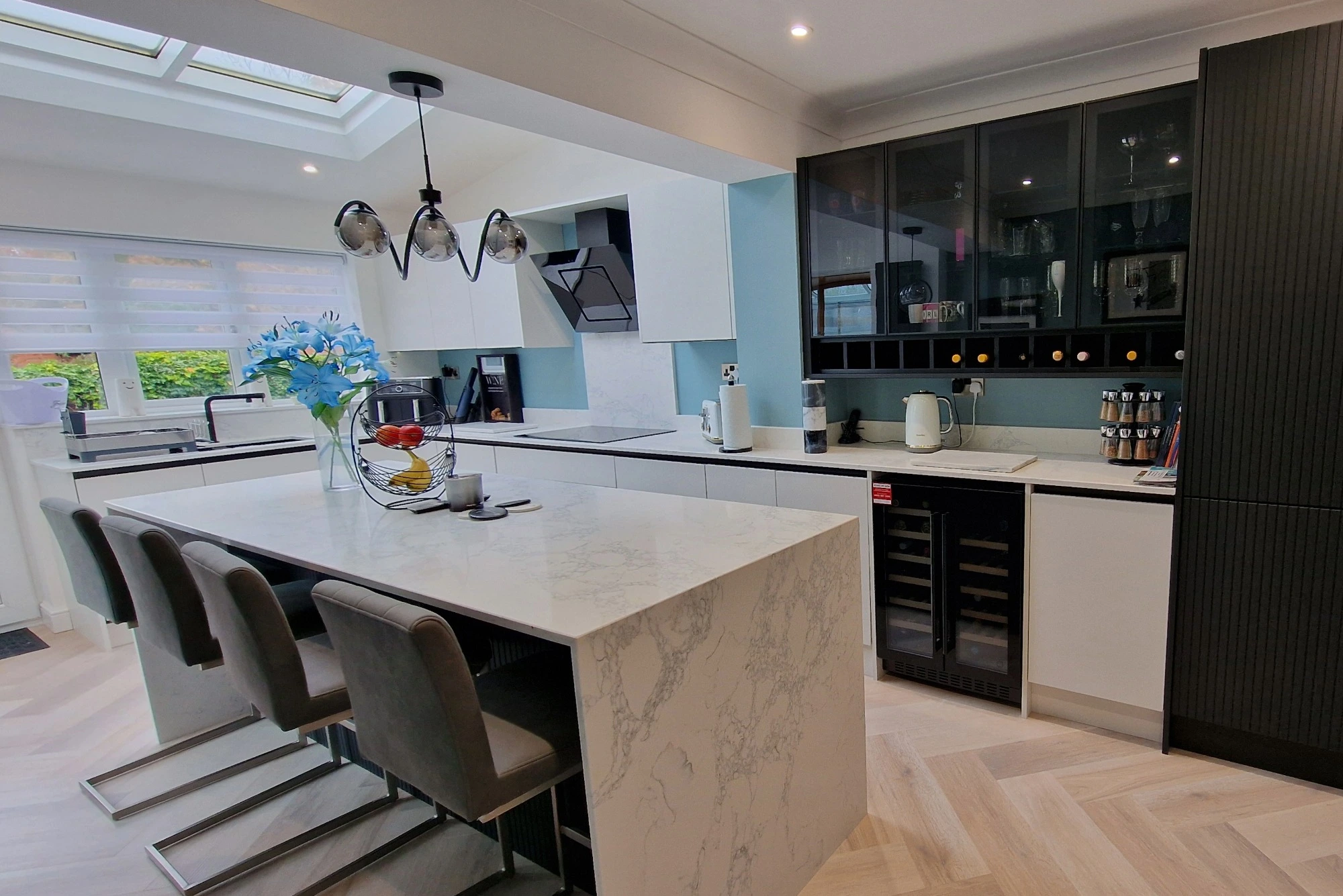 A large, contemporary kitchen with a long island in a white, black, and blue colour scheme.