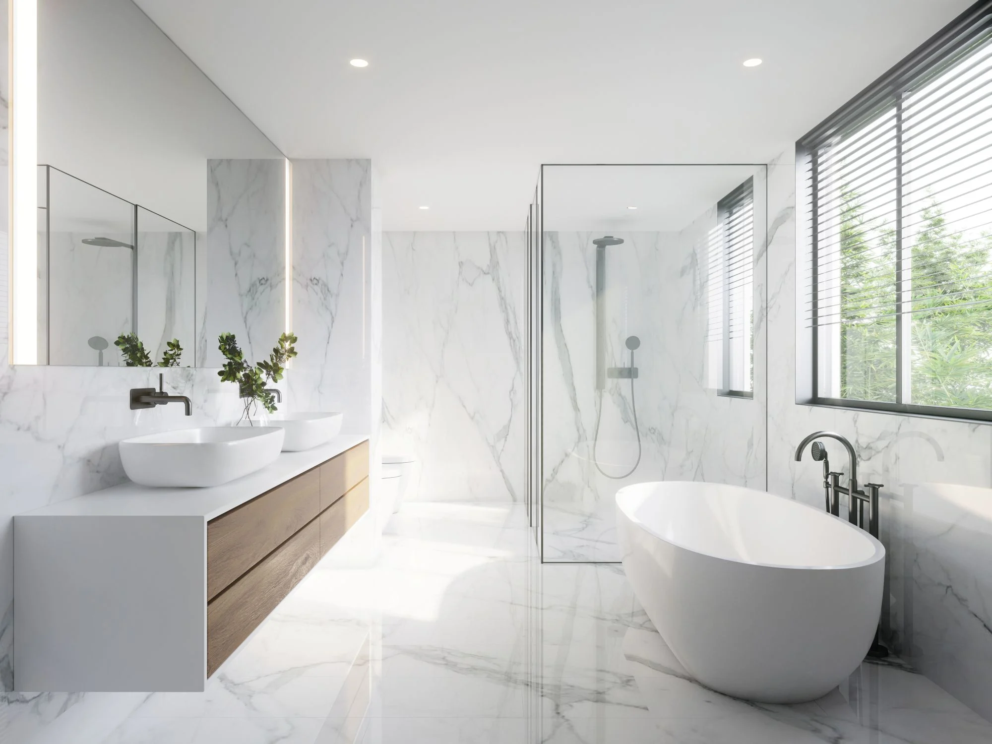 Luxurious modern bathroom fully tiled in white marble, featuring a freestanding tub, walk-in shower, and double vanity.