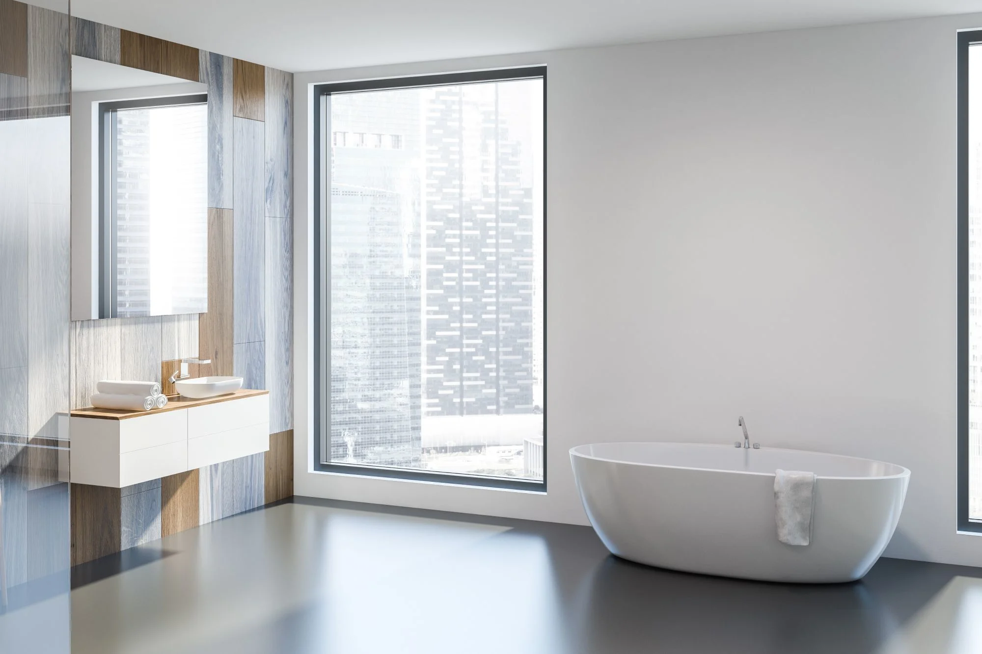 Modern bathroom with a city view, floating double vanity, and a freestanding oval bathtub.