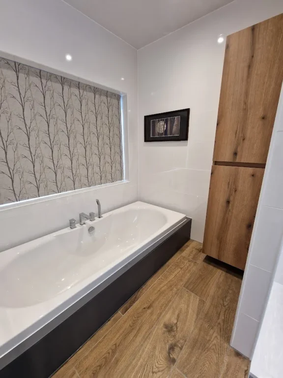 Low-lying built-in bathtub with wooden accents.