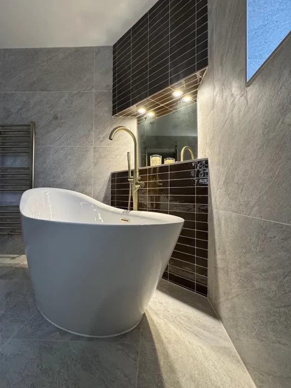 Freestanding white tub with gold tap.