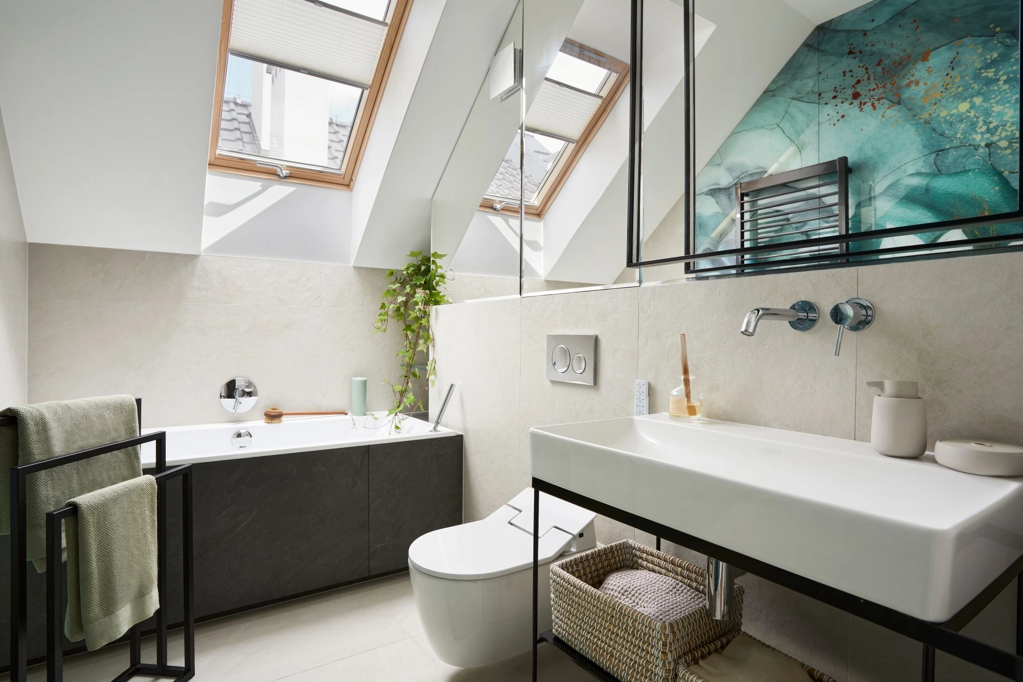 A compact bathroom with a sunlight, bath, wall mounted sink and mirror.