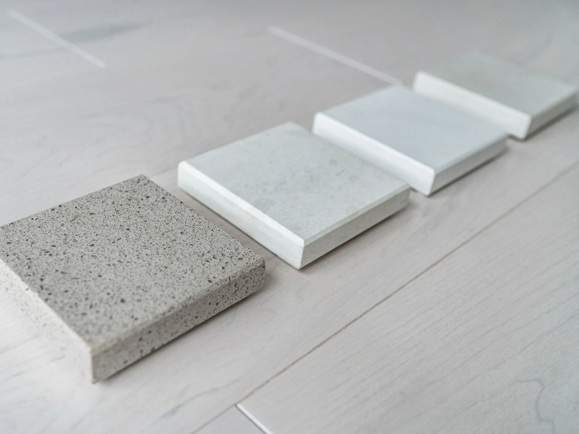 Square samples of granite worktops in neutral shades.